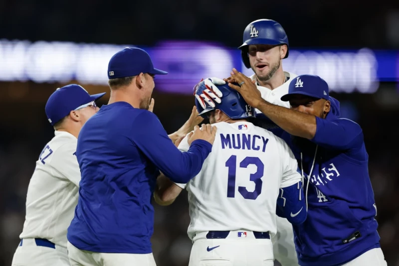 Max Muncy, de los Dodgers, es felicitado por sus compañeros luego de poner fin al duelo ante los Reales con un sencillo en la décima entrada, el 11 de agosto de 2026.