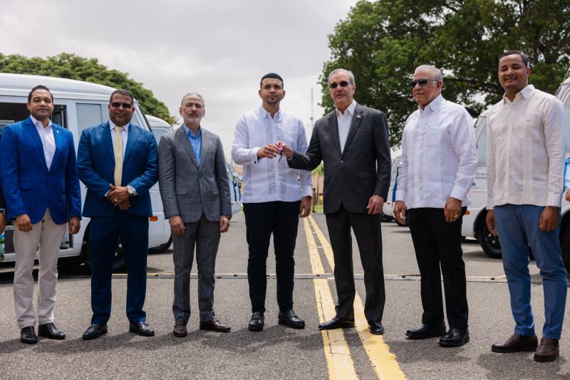 El presidente Luis Abinader entrega al ministro de la Juventud, Carlos Valdez, la llave de uno de los autobuses, durante un acto realizado ayer.