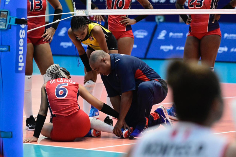 César Villalona, fisioterapeuta de las Reinas del Caribe, mientras asistía en plena cancha a la armadora Camila de la Rosa.