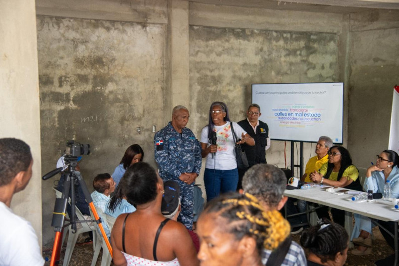 Comunitarios y agentes de la policia nacional presentes en el "Dialogo por la convivencia barrial" en la comunidad de Villa del Norte, en Licey.