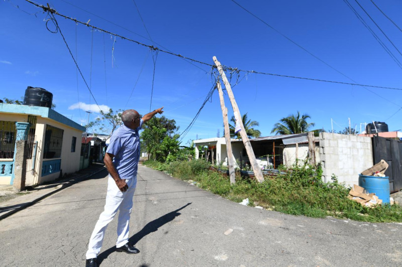 José Luis Peña Polanco señala uno de los postes de luz en deterioro.