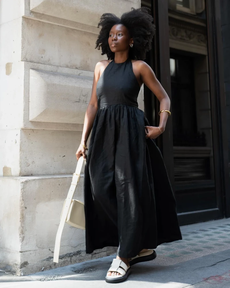 Vestido negro estilo tank y sandalias blancas.
