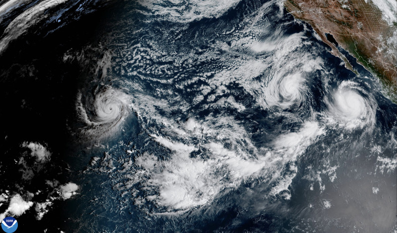 Esta imagen satelital, proporcionada por la Administración Nacional Oceánica y Atmosférica (NOAA), muestra los huracanes Polo (derecha), Odalys (más al norte) y Nolo (izquierda) sobre el Pacífico oriental el 26 de septiembre