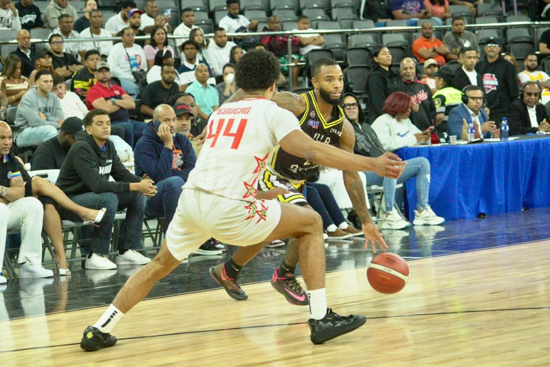 Marquis Wright, del club Rafael Barias, es defendido por Geancarlos Peguero, del Bameso.