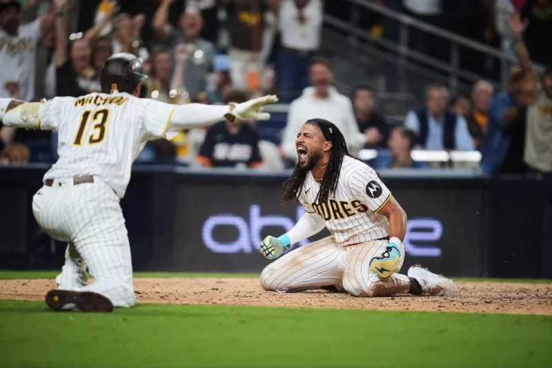 Fernando Tatis Jr., de los Padres, celebra con Manny Machado tras anotar mediante un robo de base y un error de los Cachorros en la séptima entrada.