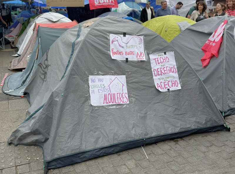 Casas de campaña con pancartas de protesta