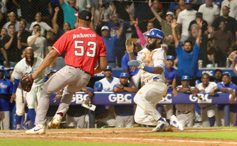 Emilio Bonifacio al momento de deslizarse en el plano que trajo la carrera del gane para el Licey.