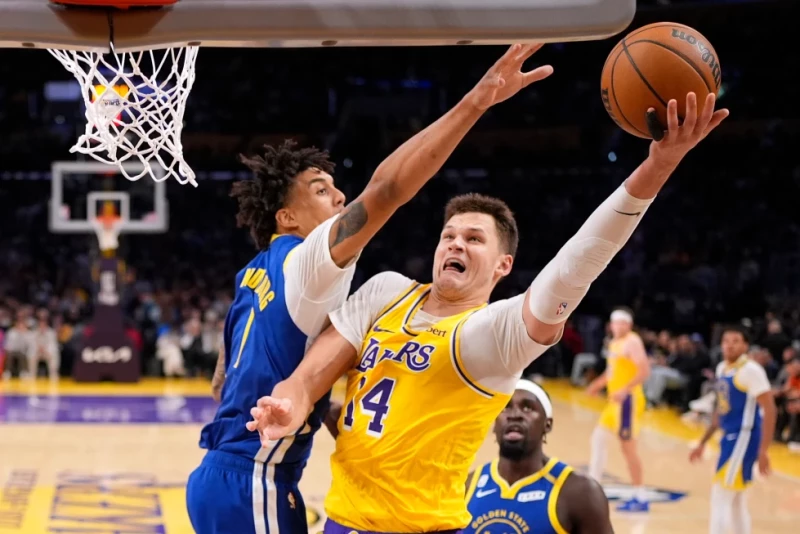 Walker Kessler, de los Lakers, lanza junto a Yaxel Lendeborg, de los Warriors, en el partido del 21 de octubre de 2026.