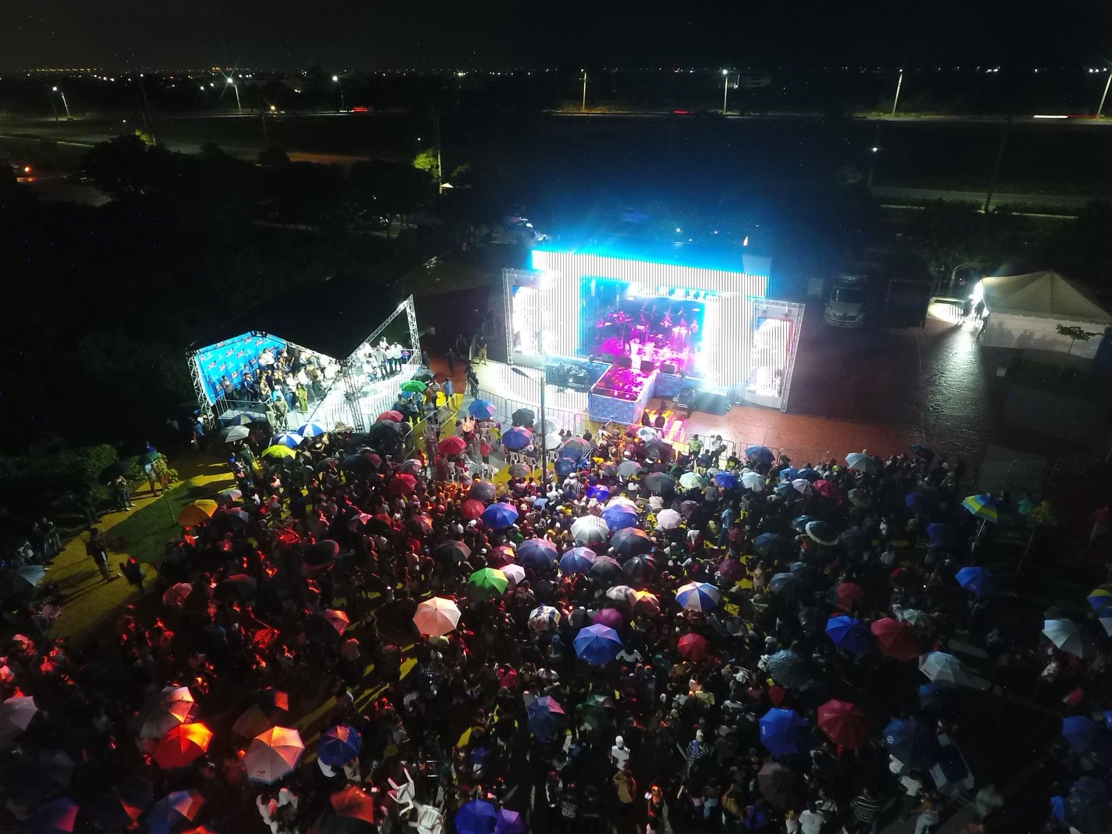El escenario móvil de Luis Medrano se ve al fondo delante de la multitud que se congregó la noche del domingo en Ciudad Juan Bosch.
