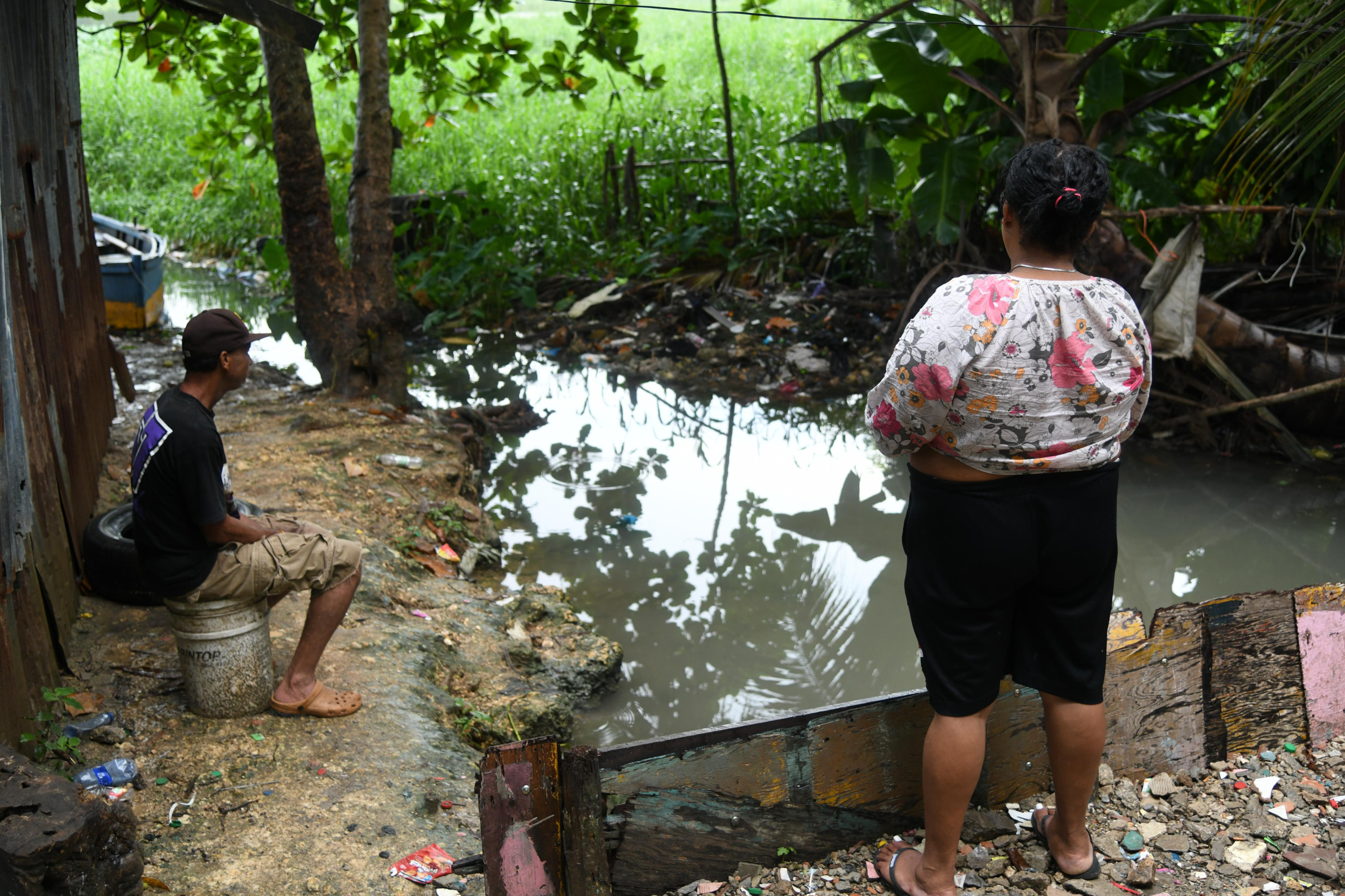 Residentes en Las Cañitas, en el Distrito Nacional, esperan que el río Ozama no provoque inundaciones.