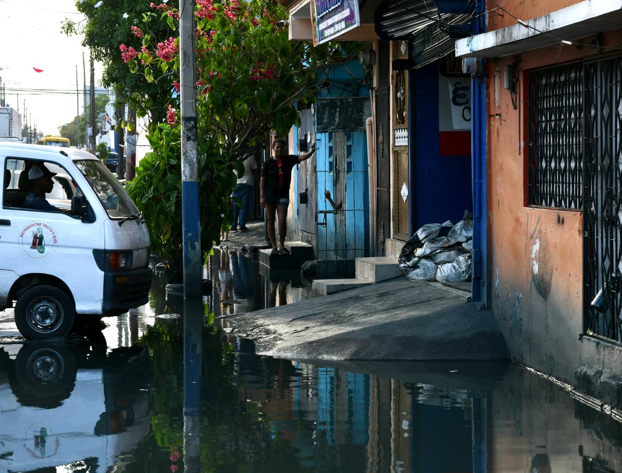 Propietarios de negocios han optado por poner sacos de arena para bloquear el paso del agua estancada.