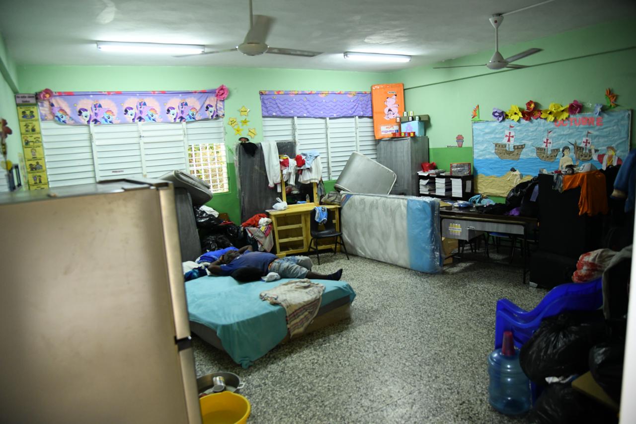 Los alojados en la ribera sacan sus pertenencias más esenciales para pasar los días durante el paso de Melissa.