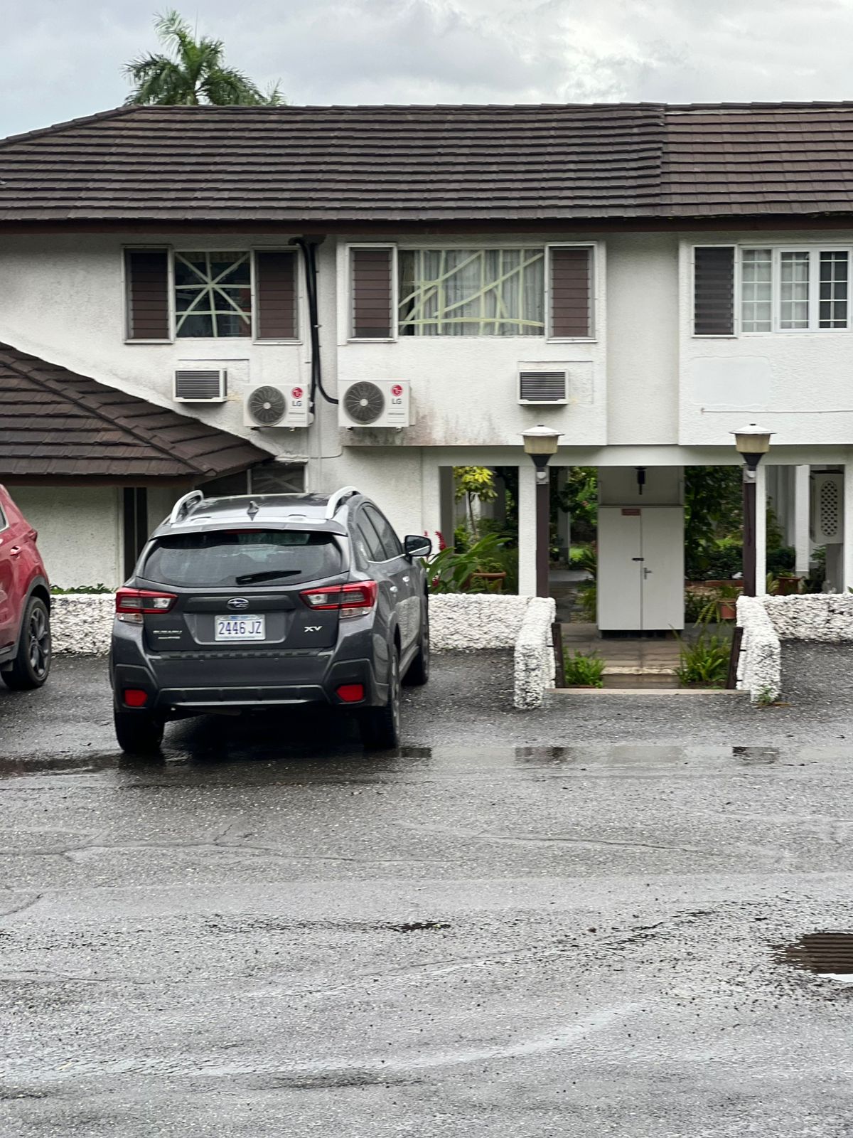 Personas aseguran sus ventanas de cristal con cinta adhesiva en Jamaica.