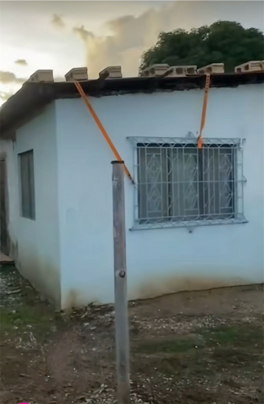 Personas aseguran sus techos con bloques de concreto, en Jamaica.