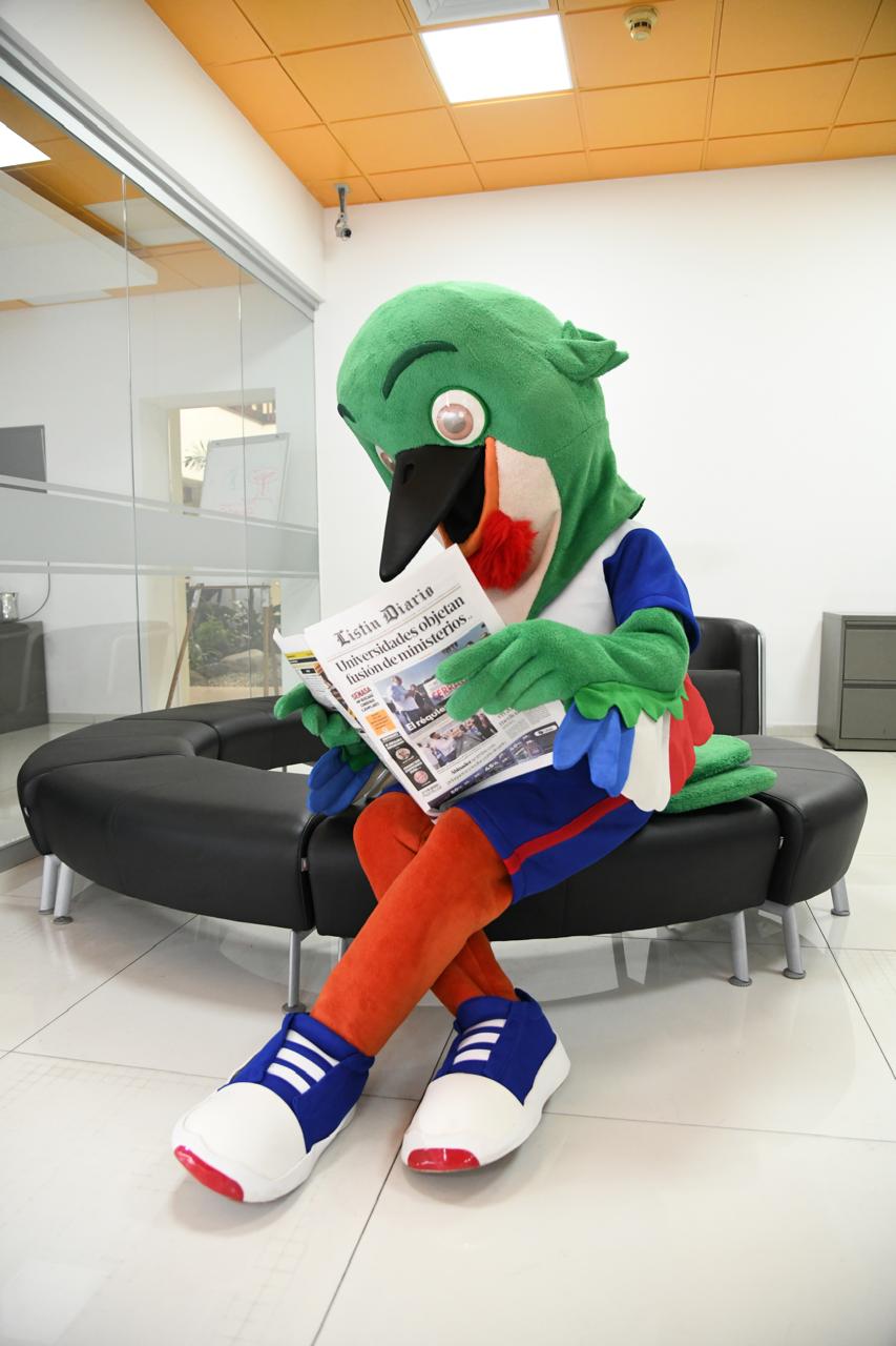Colí, la mascota de los Juegos Centroamericanos y del Caribe Santo Domingo 2026, posa con el periódico de Listín Diario.