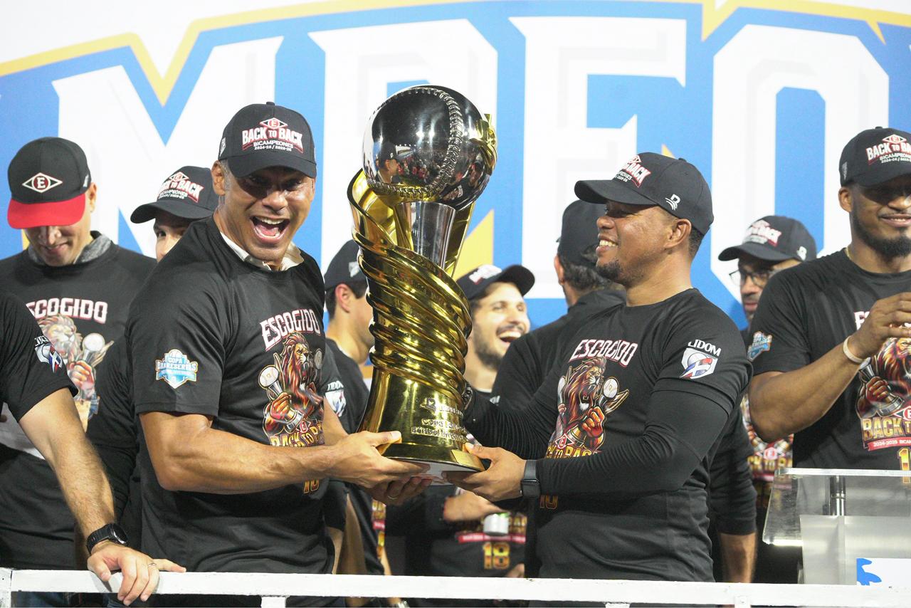 El gerente Carlos Peña y el dirigente Ramón Santiago sostienen el cetro de campeón de Lidom en la temporada 2025-2026.