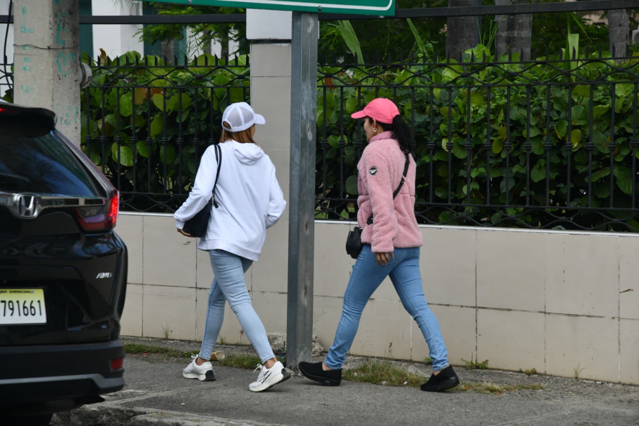 Dos jóvenes caminan abrigadas por una calle de Santo Domingo