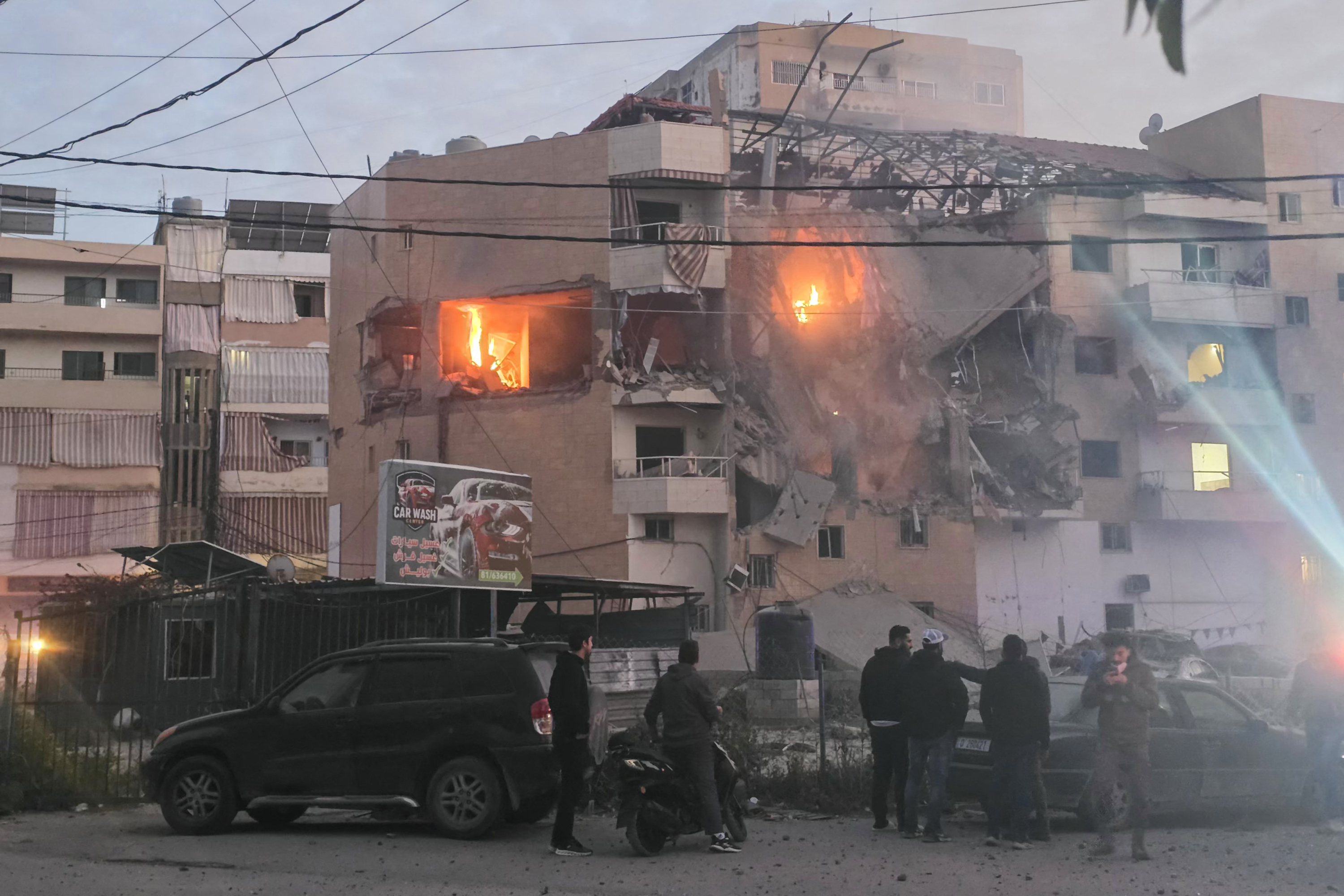 Personas se reúnen frente a un edificio que fue blanco de un ataque aéreo israelí en la ciudad costera de Tiro, al sur del Líbano, el 11 de marzo de 2026.