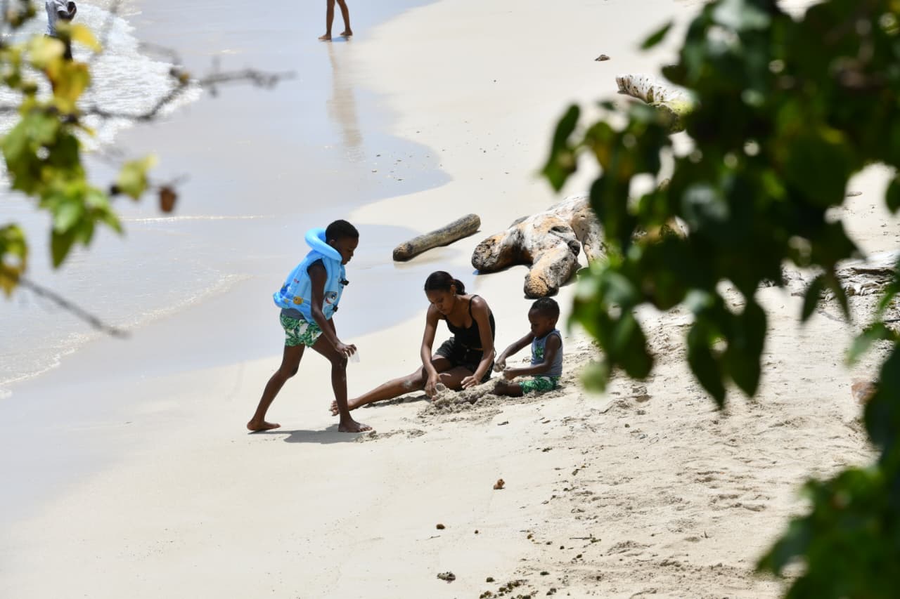 Niños juegan en la arena en la playa de La Romana.
