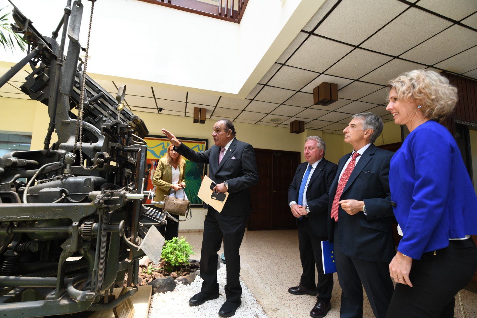 The director of Listín Diario, Miguel Franjul, shows the ambassadors one of the first printing presses that the dean of the national press had.