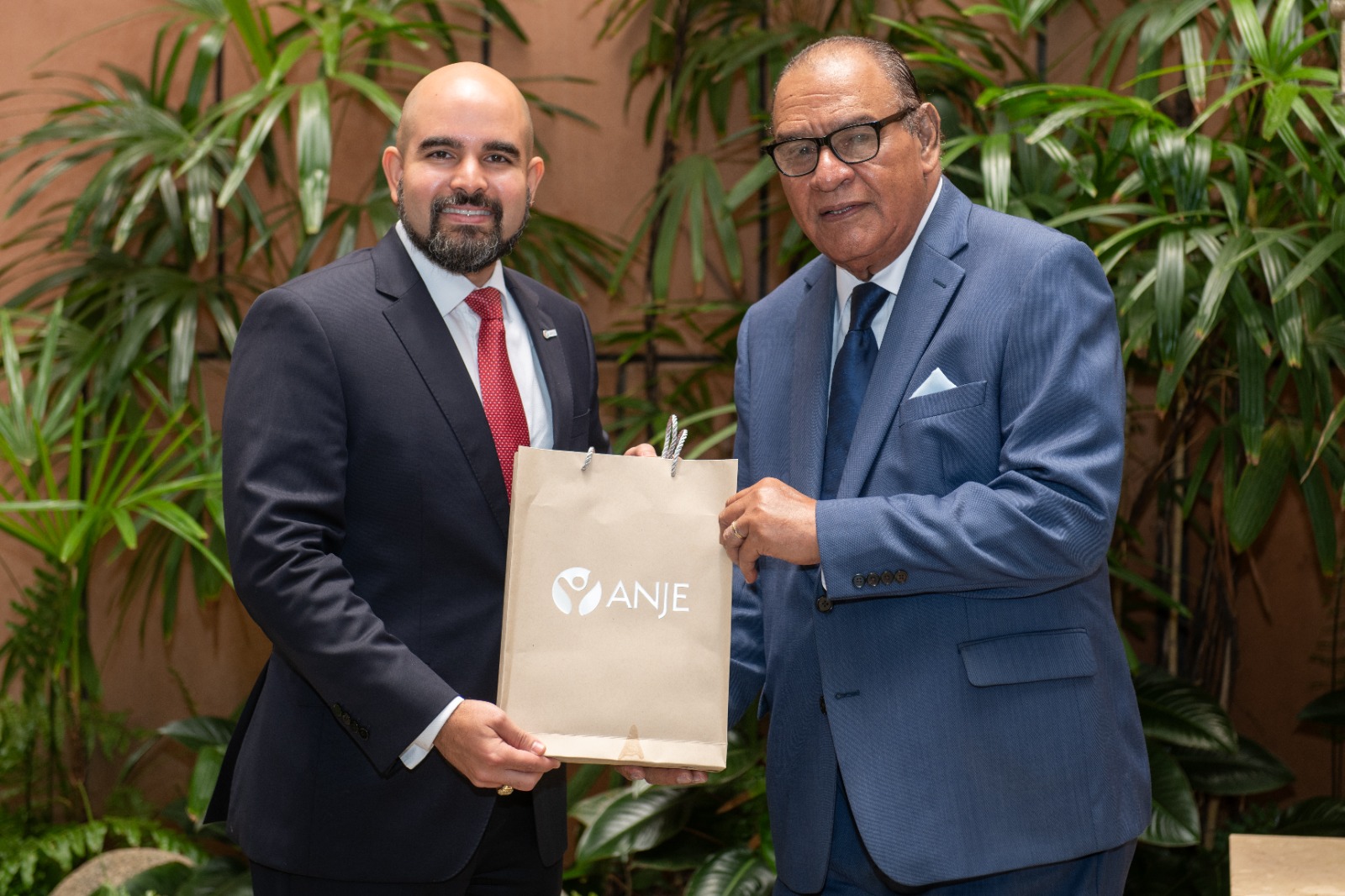 Boris de León Reyes entrega a Miguel Franjul documentos con historia de ANJE y sus memorias de 2025.