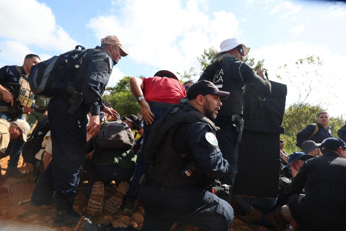 The image, distributed on June 19, 2026 by Grupo Extra, shows members of a security detail crouching and protecting Costa Rican President Laura Fernández with shields after an explosion that occurred during a visit to an illegal mining area in Crucitas, near the border with Nicaragua.