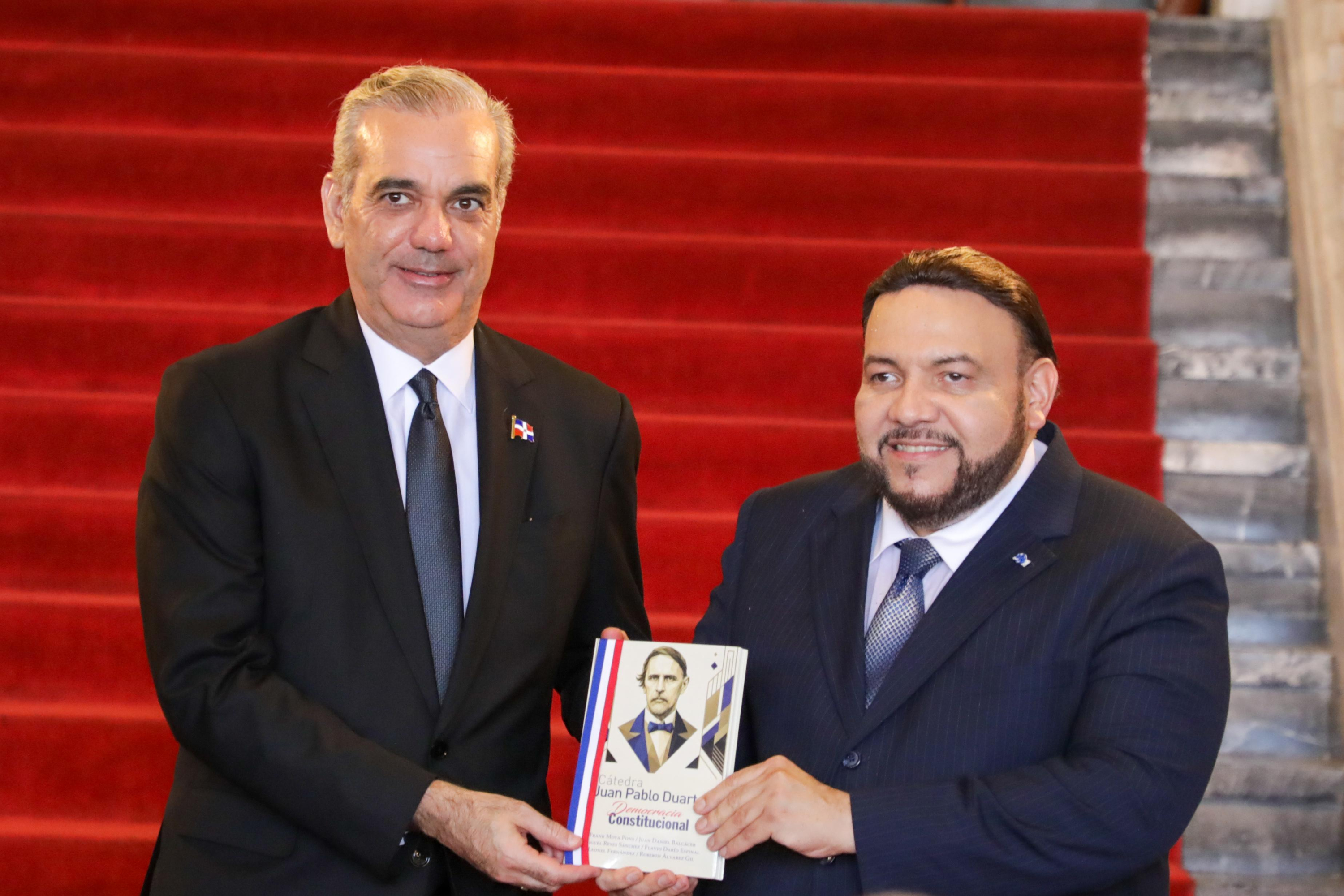 El presidente de la Academia Dominicana de la Historia, Miguel Reyes, le entregó la obra a Abinader.