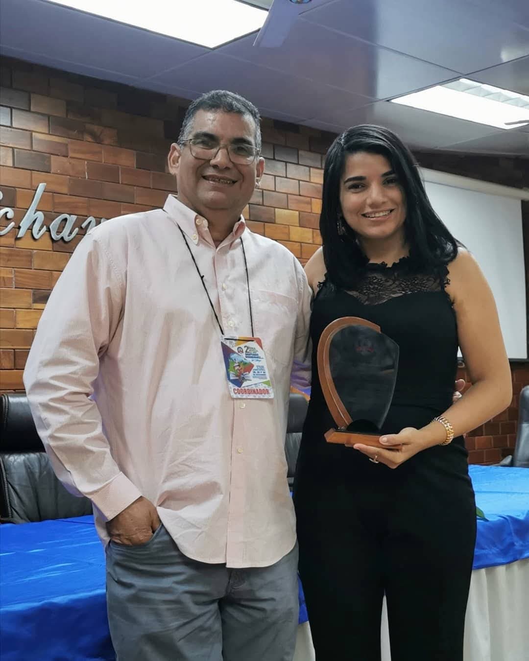 Keila y su tío Ricardo, con el reconocimiento que le entregaron en la Feria Regional del libro en reconocimiento a su trabajo con la literatura