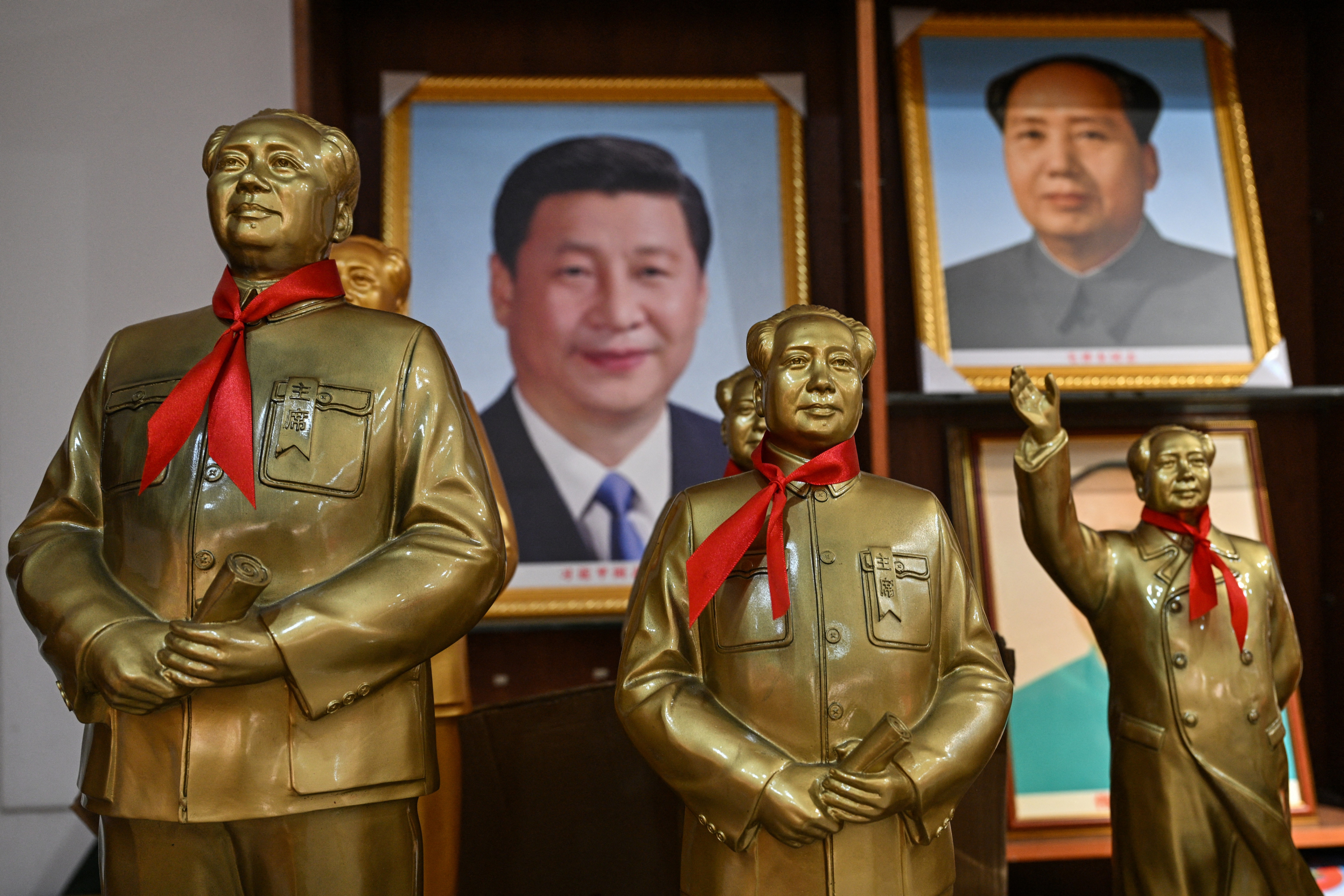 Se observan estatuas del fallecido líder comunista Mao Zedong detrás de un retrato del presidente chino Xi Jinping (al fondo, a la izquierda) en una tienda de Shaoshan, en la provincia central china de Hunan, el 8 de septiembre de 2026, un día antes del 50.º aniversario de su muerte. (Foto de Hector RETAMAL / AFP)